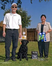 Dog training instructor with judge holding competition awards and his dog