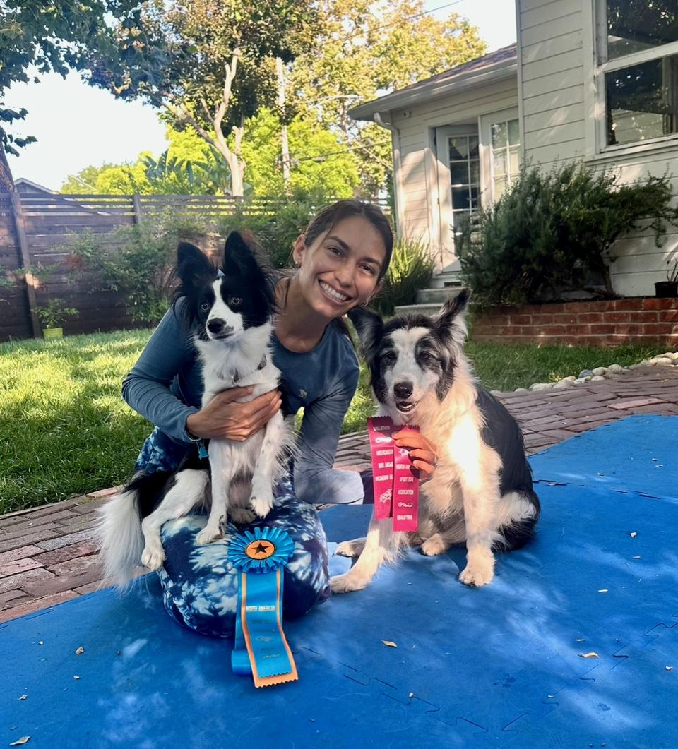 Dog training instructor holding AKC FIT Dog awards