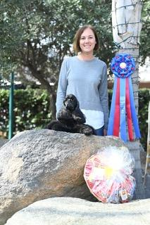 Dog training instructor holding AKC Rally award with her dog