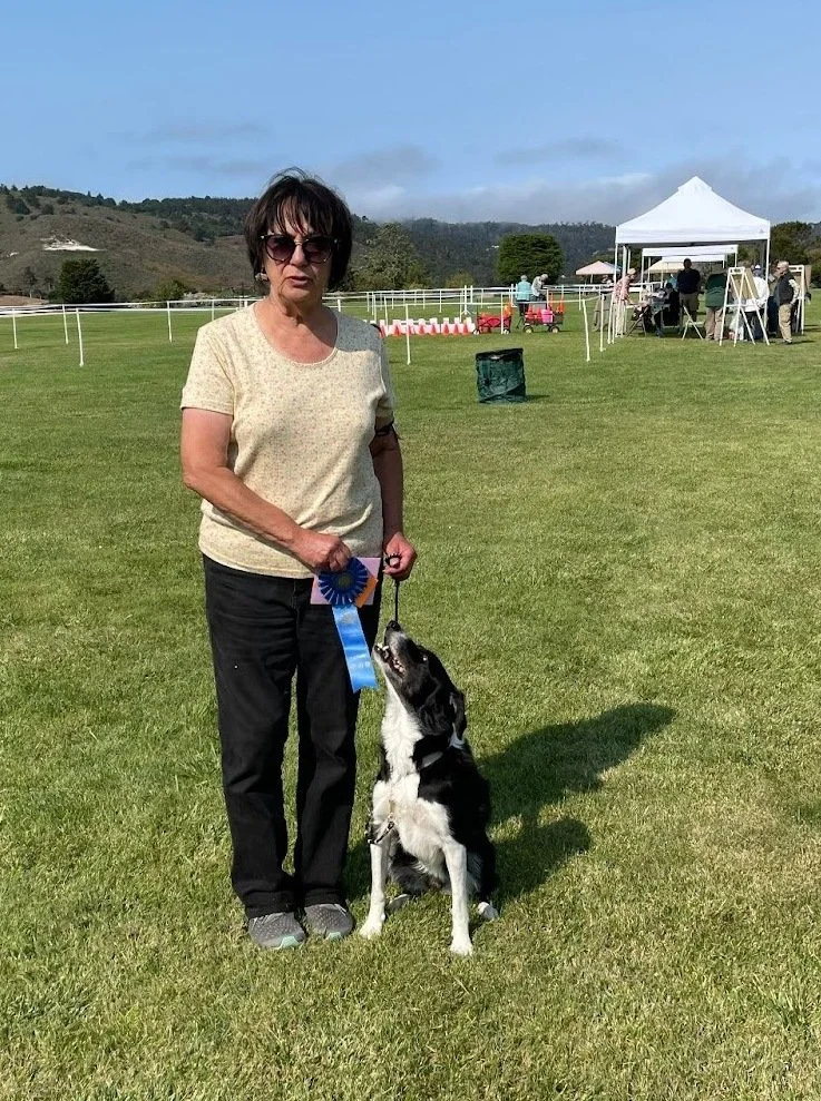 Dog training instructor holding AKC Obedience Utility award with her dog