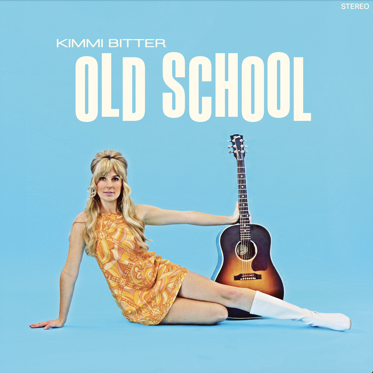 Album cover for Kimmi Bitter's 'Old School' featuring a woman in a vintage orange patterned dress with knee-high white boots, sitting on a blue background, with a guitar beside her, and text at the top.