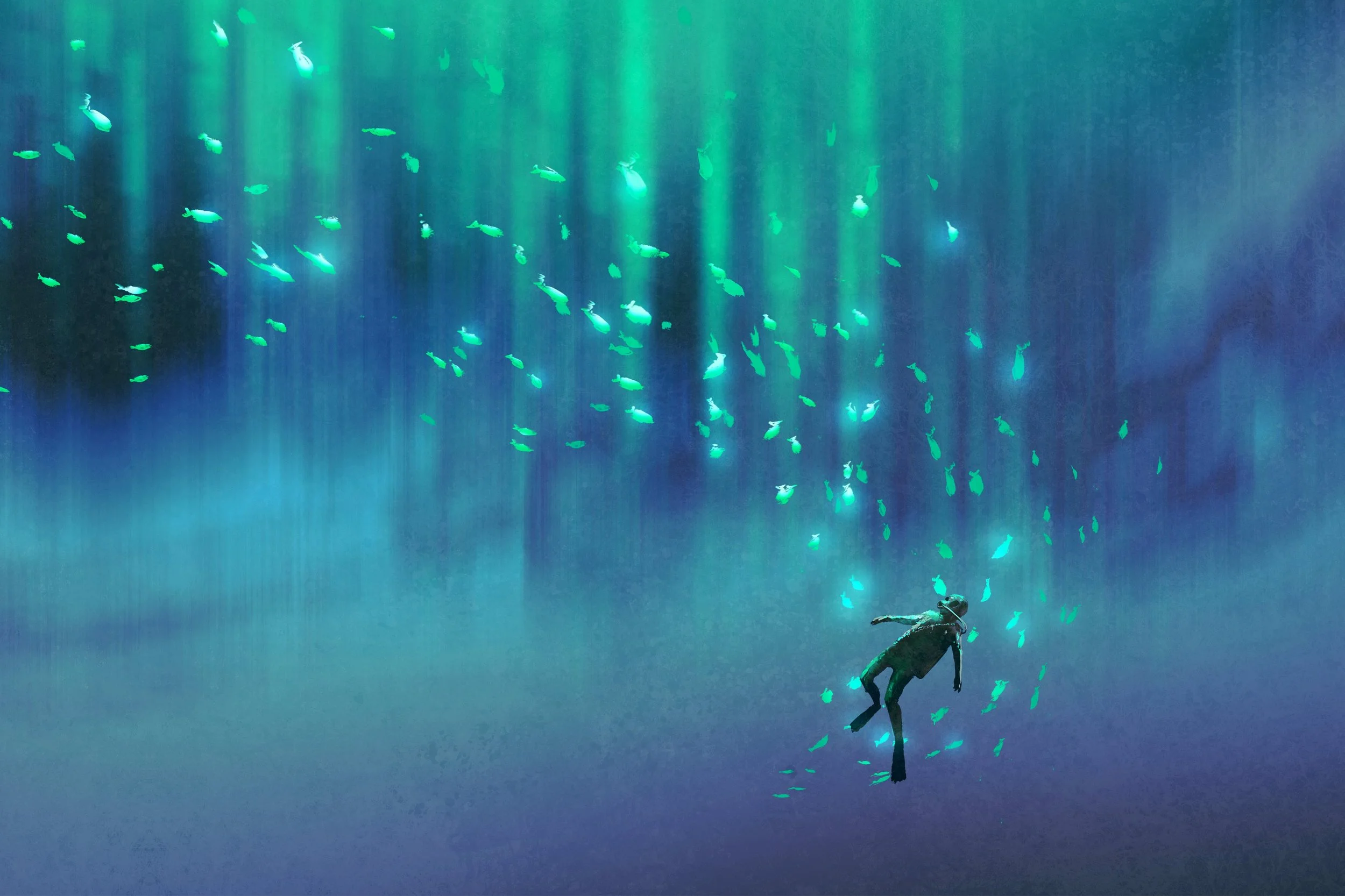 A diver swimming underwater surrounded by a school of small fish, with green and blue light filtering through the water.