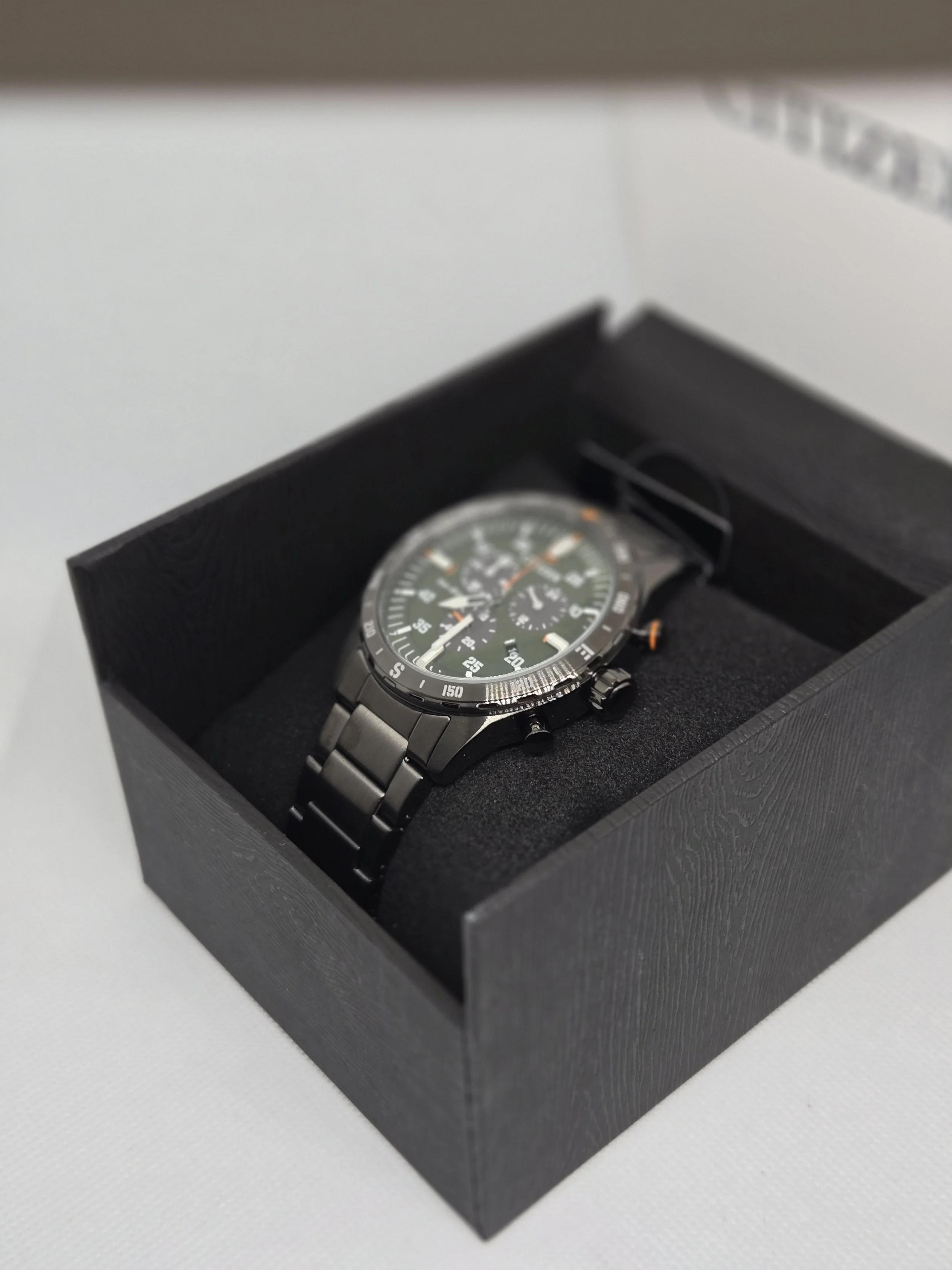 Citizen Eco-Drive chronograph watch with green dial, stainless steel case, and metal bracelet