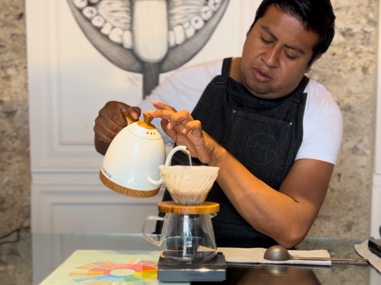 Un homme prépare du café à l'aide d'une cafetière à dépression dans une cuisine. Illustration de slow coffee, la méthode d'extraction est un V60