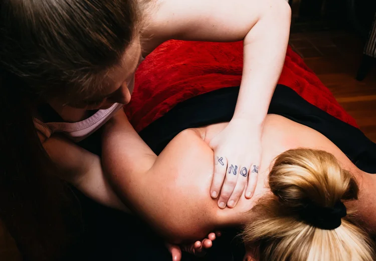 Peyton working on a client's shoulders during a massage
