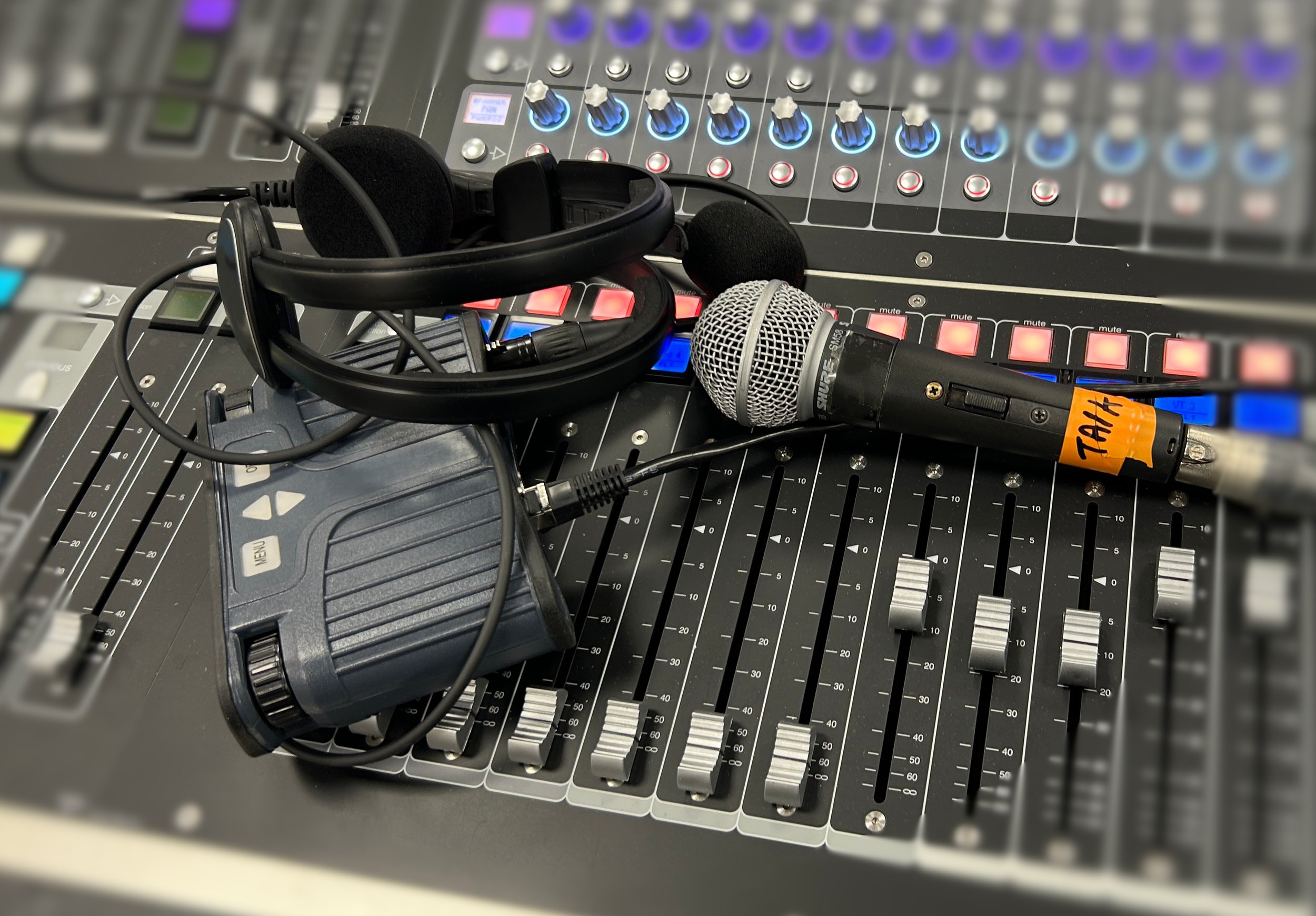 Mixing console with comms headset and talkback mic showing the challenges of managing comms and audio monitoring.