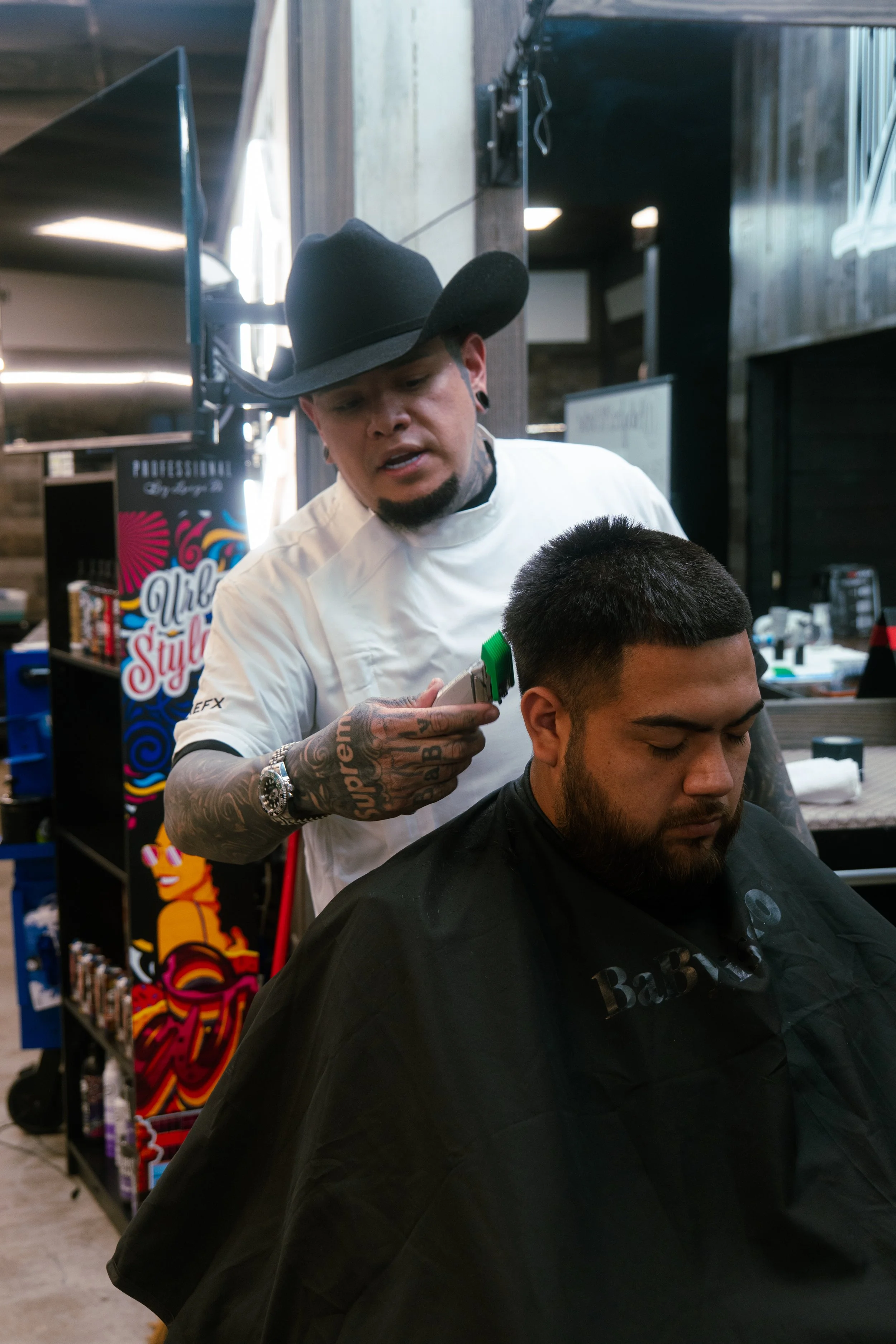 Barber cutting a man's hair in a barbershop.