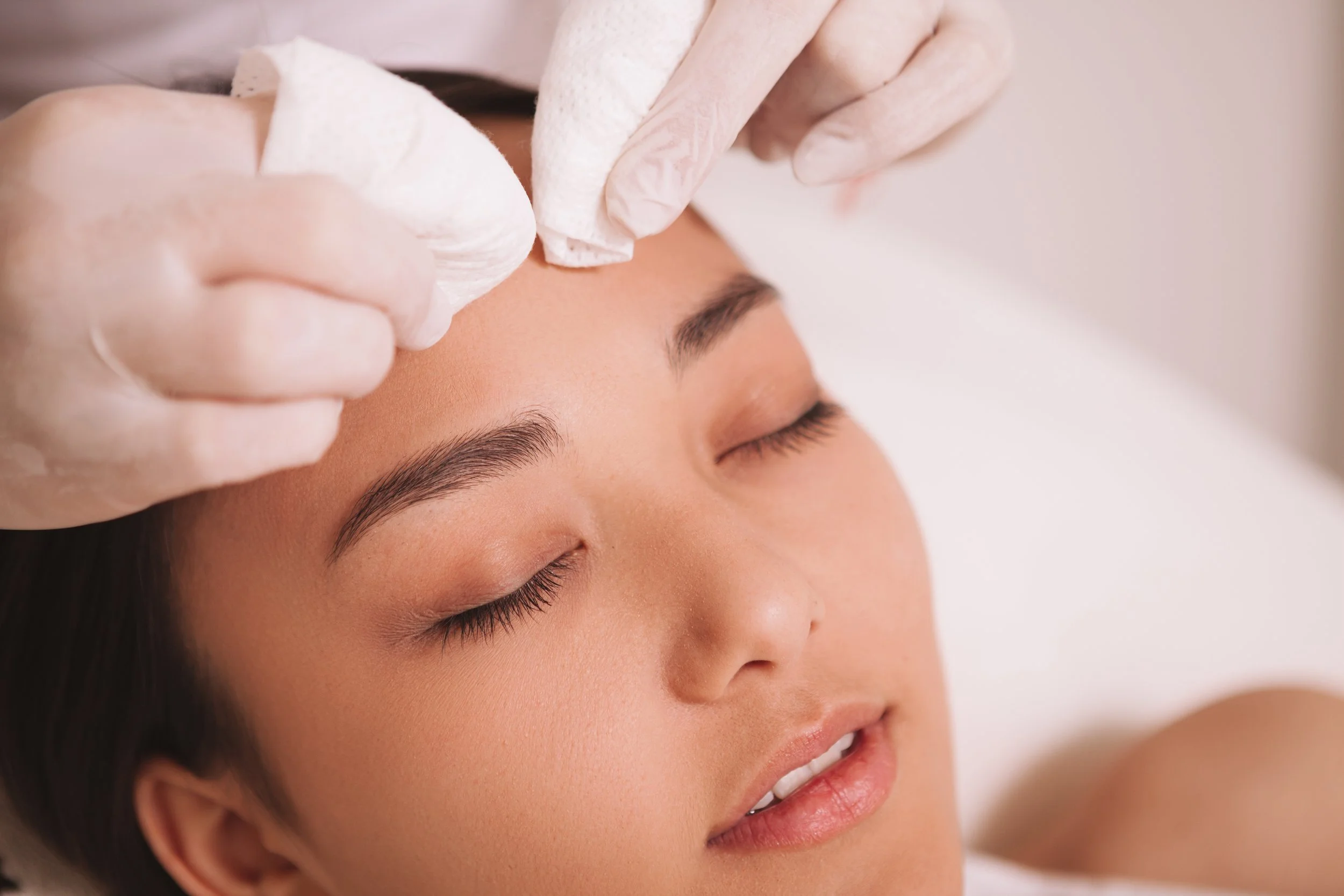 Esthetician performing facial extractions to clear clogged pores during a custom facial at Eleva Glow in Woodbridge