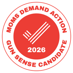 Red circular sticker with white text and a graphic. The text reads 'Moms Demand Action Gun Sense Candidate 2026.' The graphic is a white badge with three vertical lines enclosed in a circle.