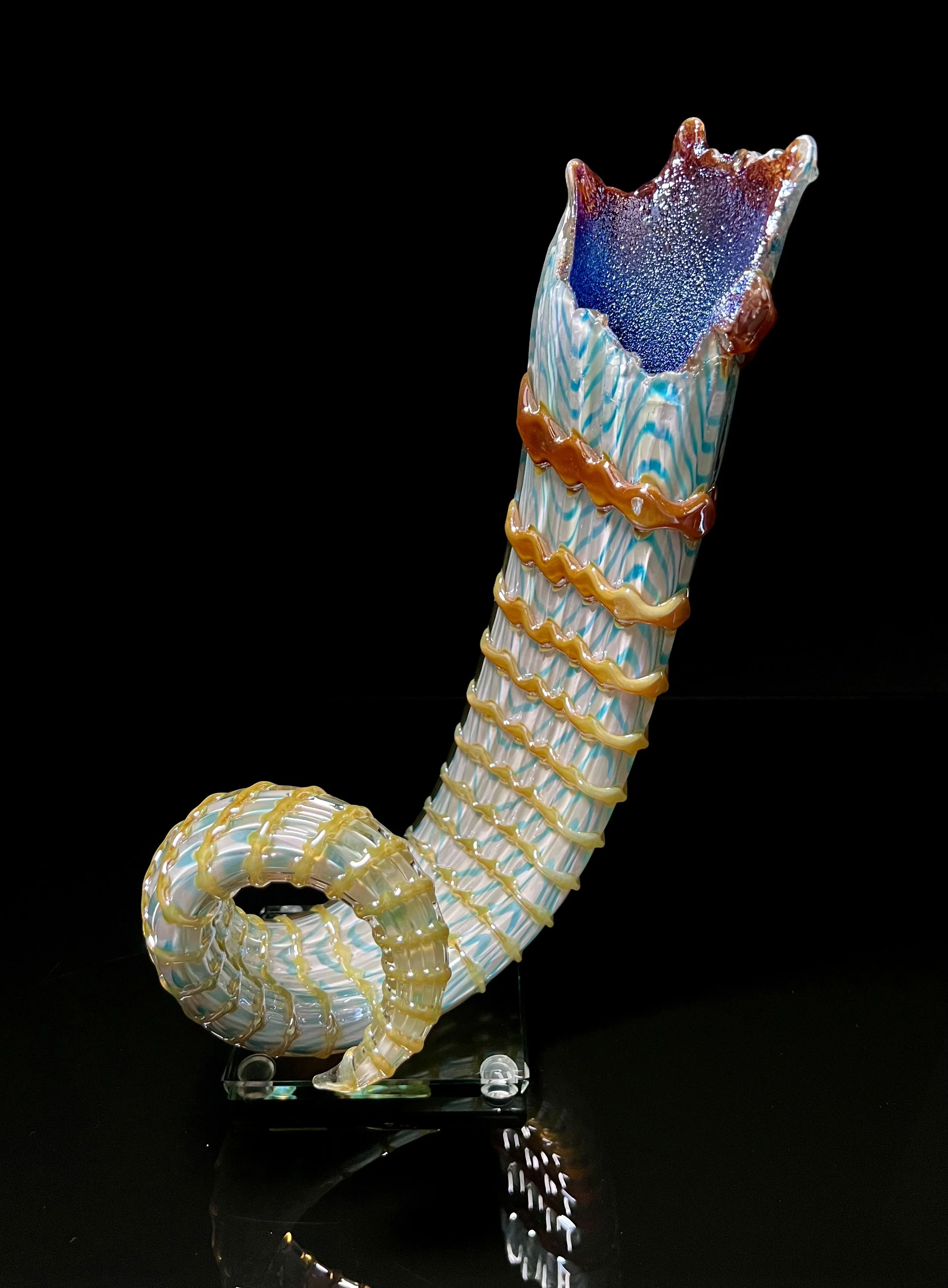 Colorful glass sculpture of a seahorse on a black background.