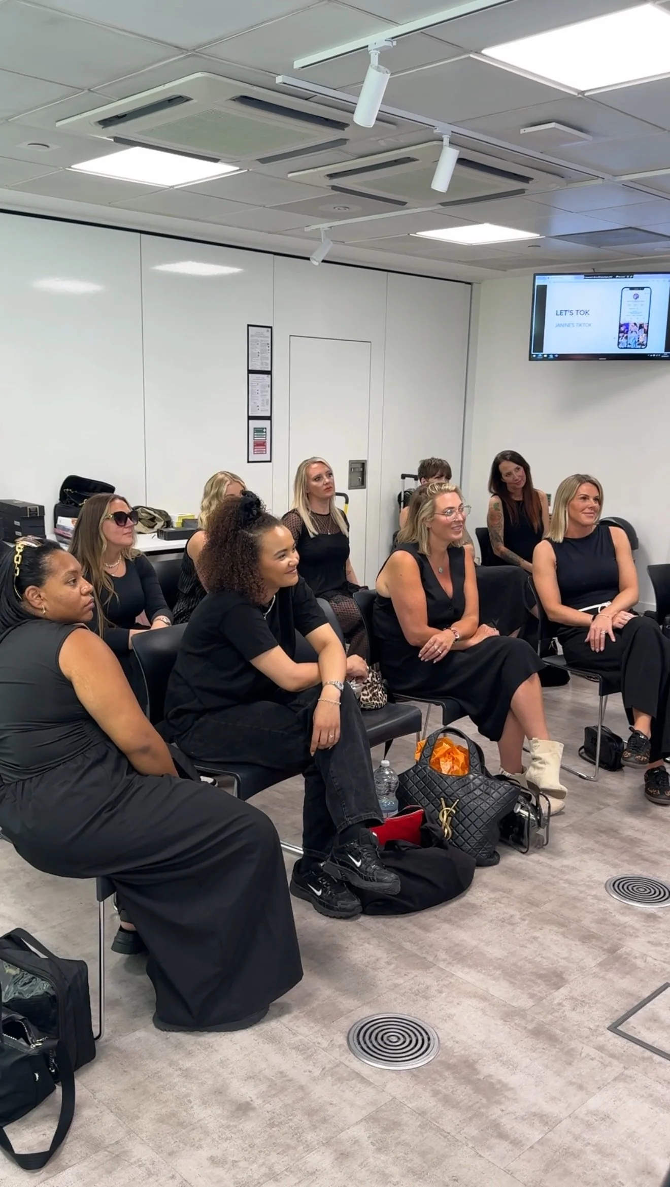 A group of women sitting in a conference room listening to a presentation.