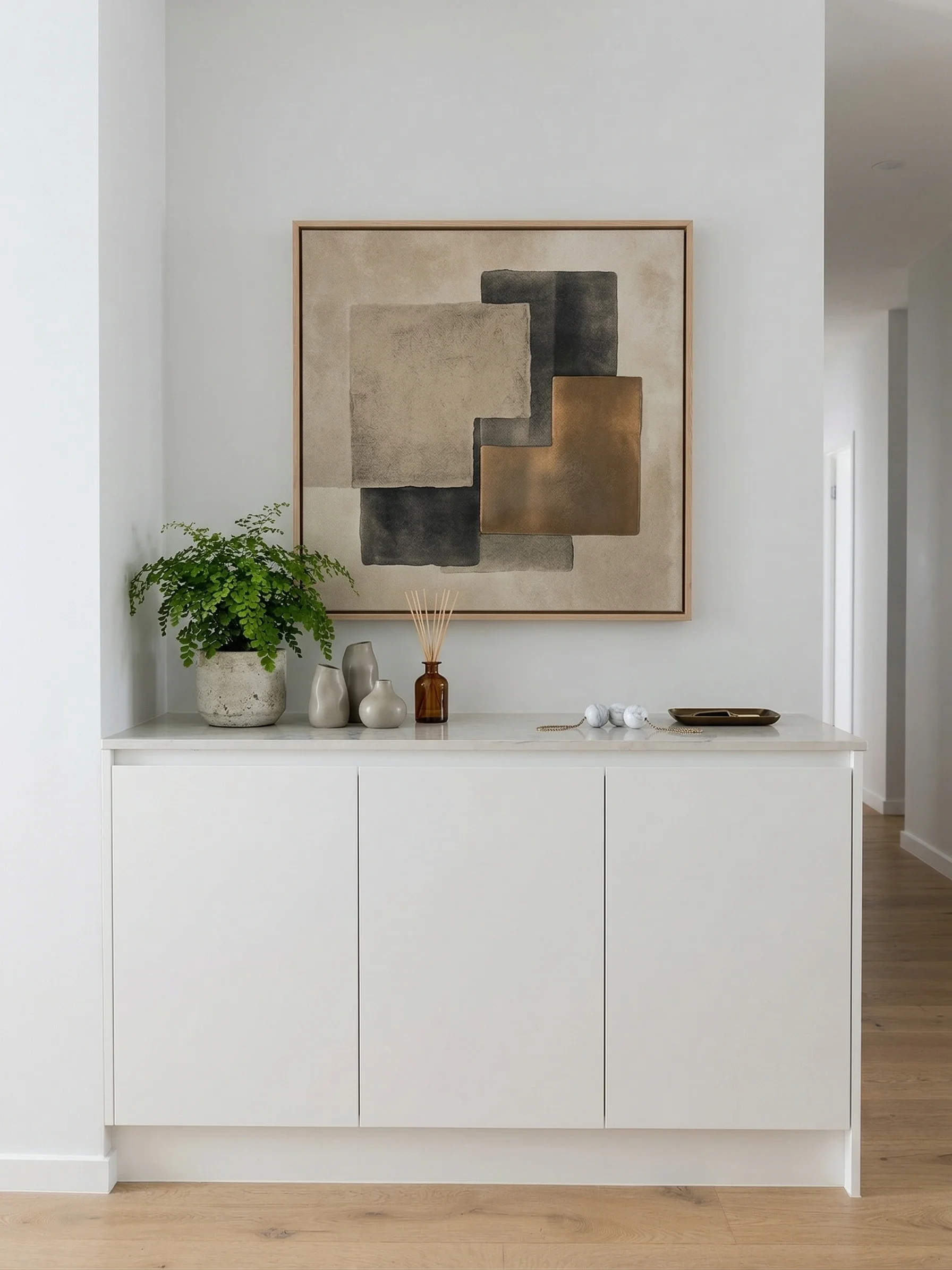 A minimalist built-in white sideboard / console with finger-pull doors for extra storage and to display decorative objects on the stone top. Custom designed, built and installed by TruJoinery in North West Sydney