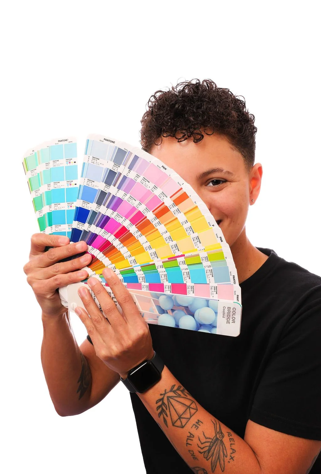 Headshot of Becky Swann holding a Pantone swatch book fanned out.