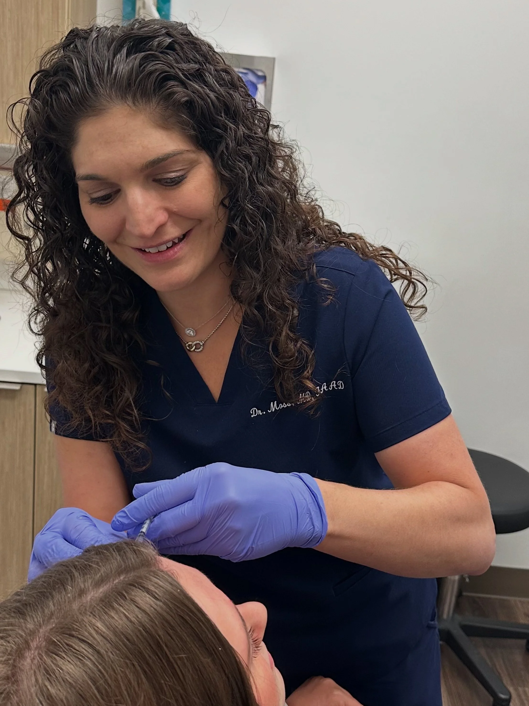 Dr. Victoria Moss, board certified dermatologist, injecting Botox on a patient.
