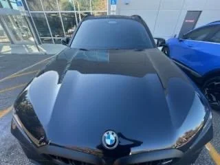 Black BMW parked outside building with glass windows
