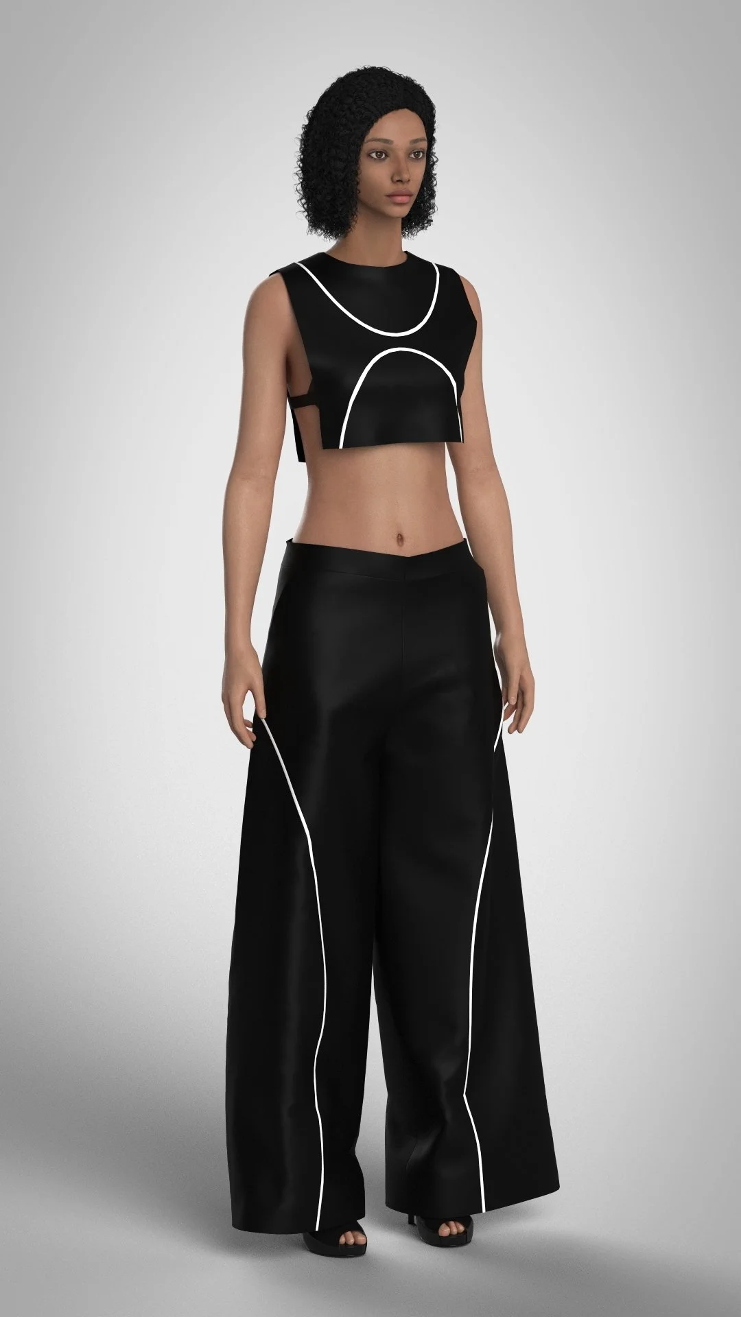 A woman with curly black hair wearing a black sleeveless crop top with white piping and wide black pants with white piping, standing against a plain gray background.