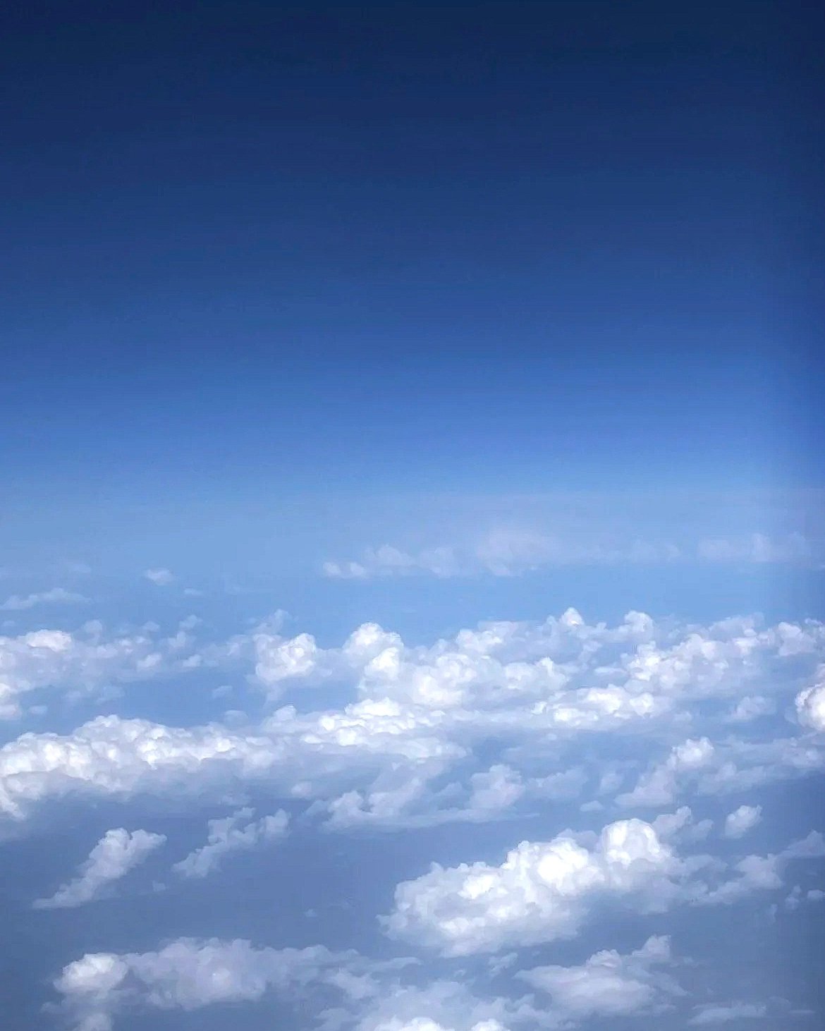 View of clouds from above, with a clear blue sky.