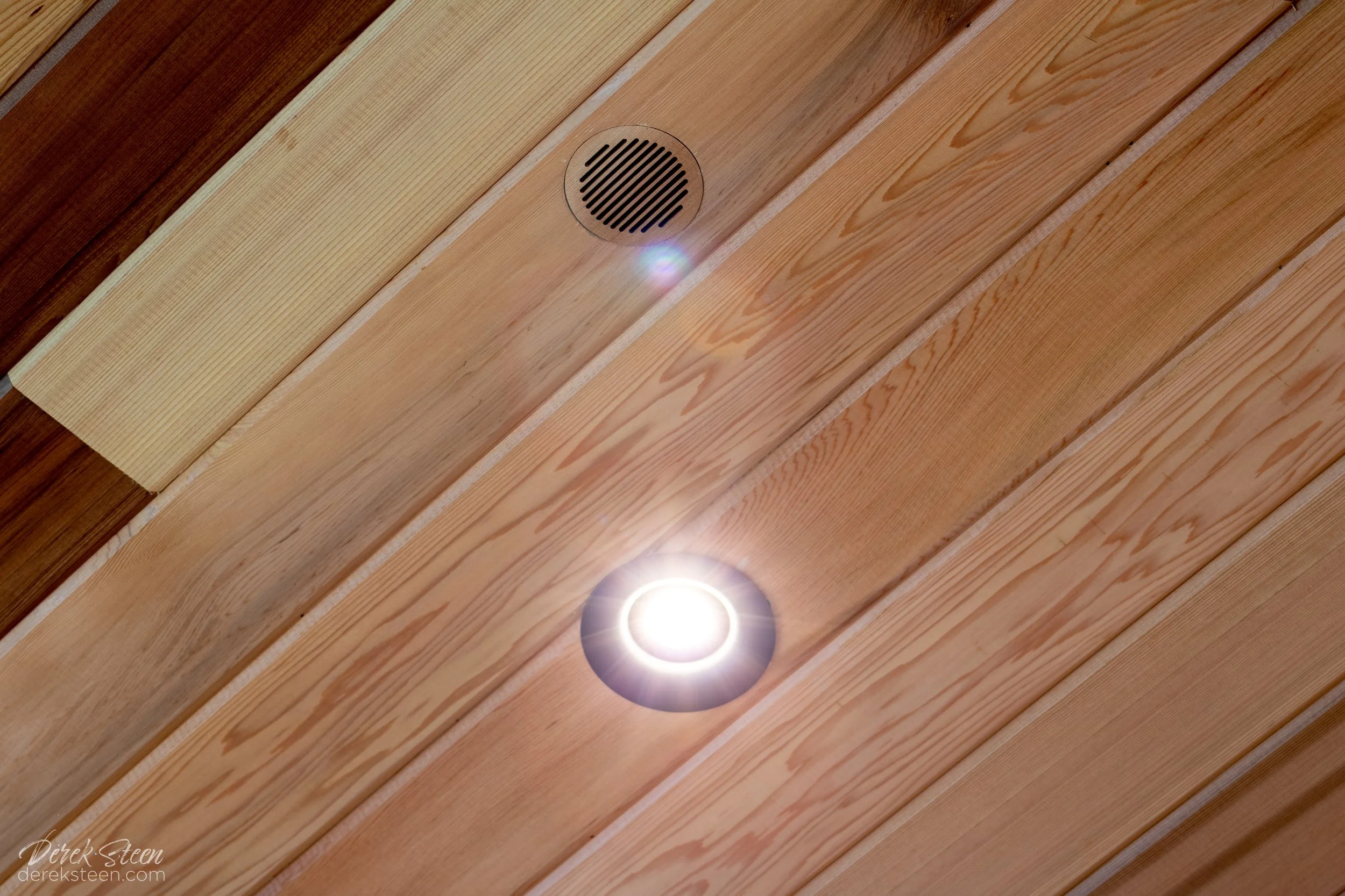 Wooden ceiling with built-in light and a small speaker grille.