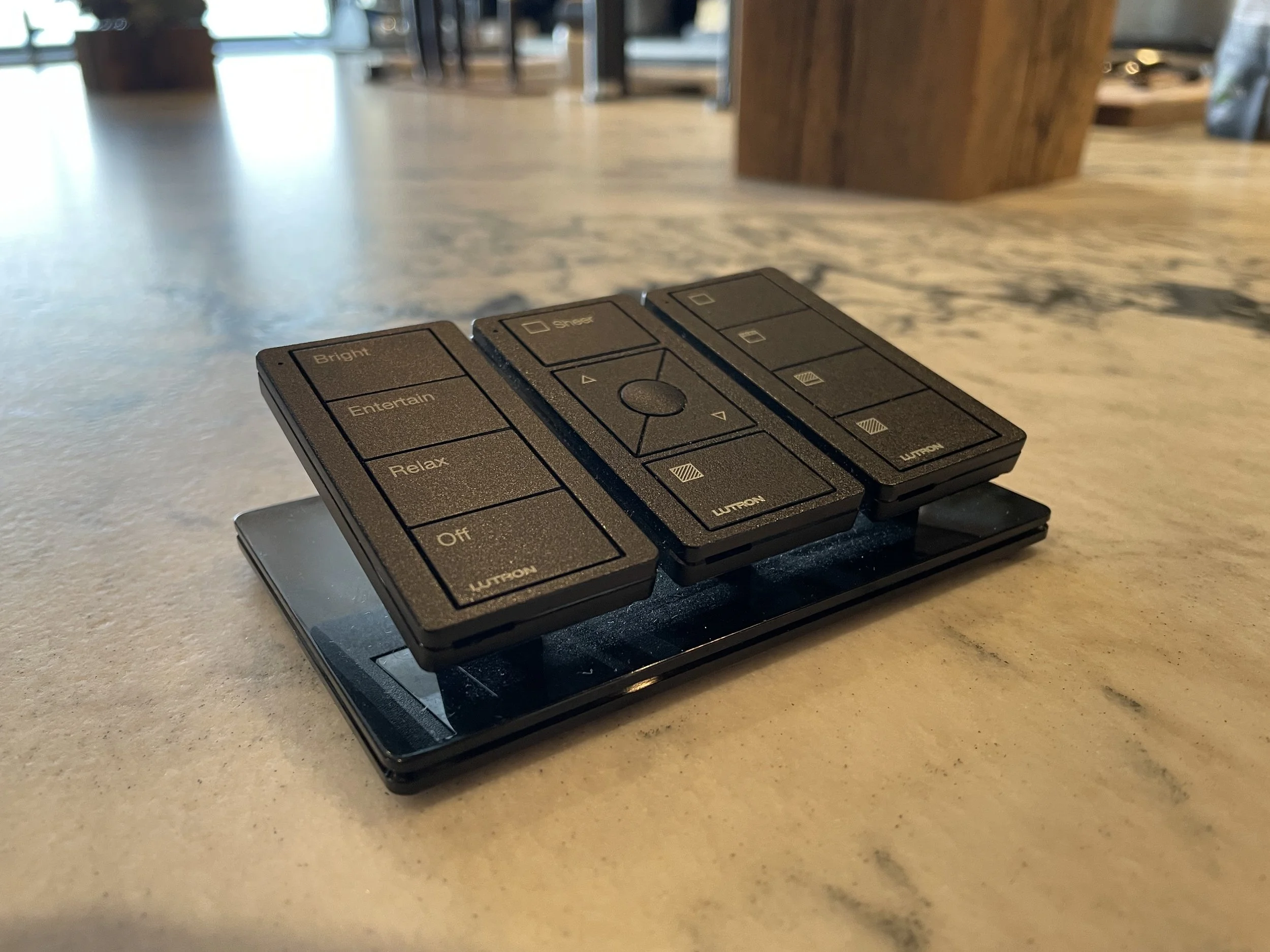 Remote control with labeled buttons for Bright, Entain, Relax, and Off functions, placed on a marble surface.