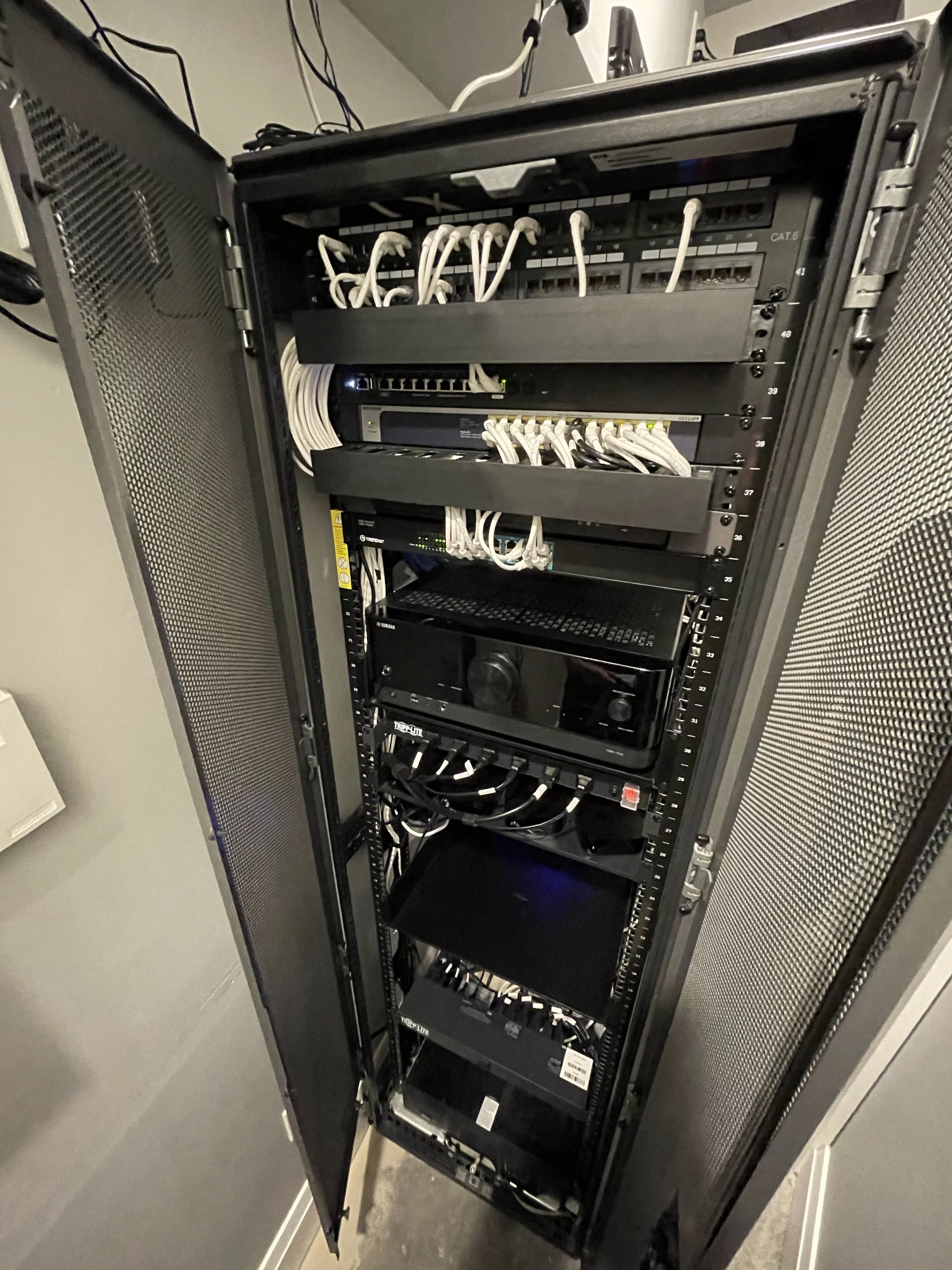 Inside a server rack with various networking equipment, switches, and cables.