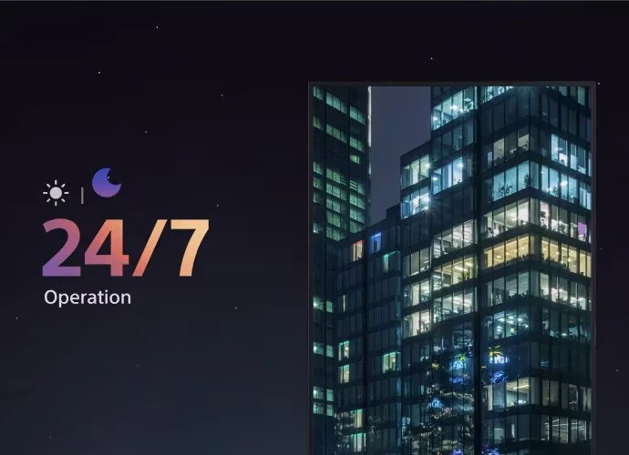 Nighttime cityscape with tall modern glass buildings and illuminated windows, alongside icons indicating 24/7 operation with a sun and moon.