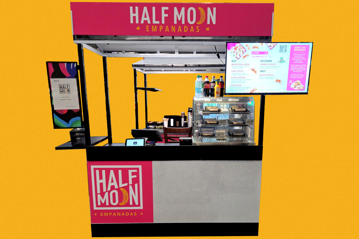 Pink and yellow food stand named 'Half Moon Empanadas' with digital menu display and glass case of empanadas