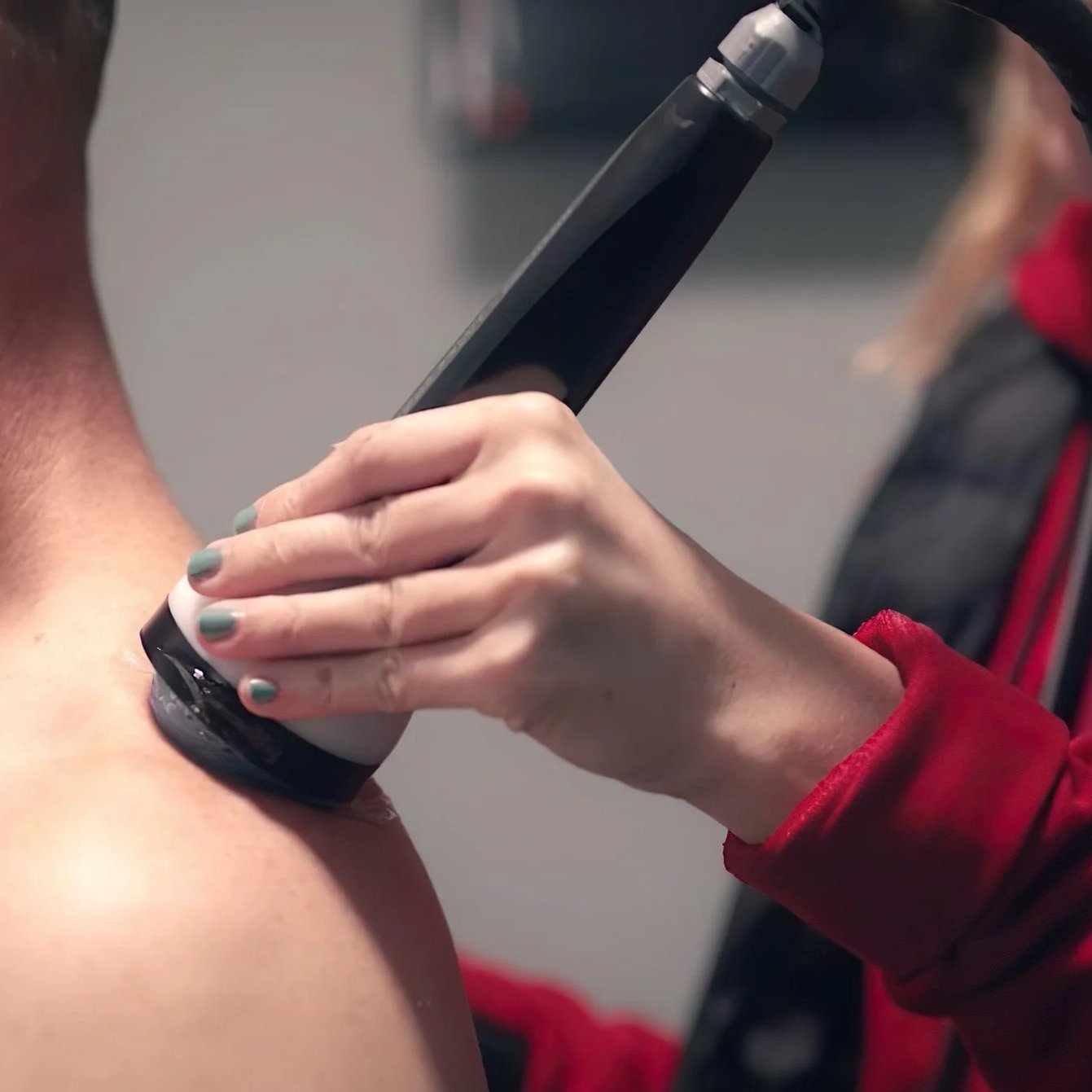 Person using StemWave regenerative therapy device on another person's shoulder.