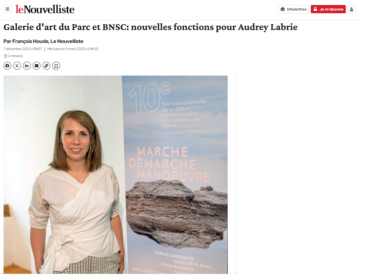 Une femme pose à côté d'une affiche promotionnelle pour une manifestation artistique.