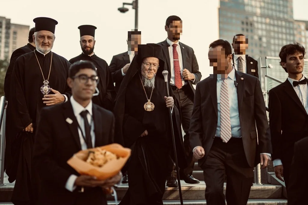 Group of religious clergy and men in suits walking down stairs in an urban area.