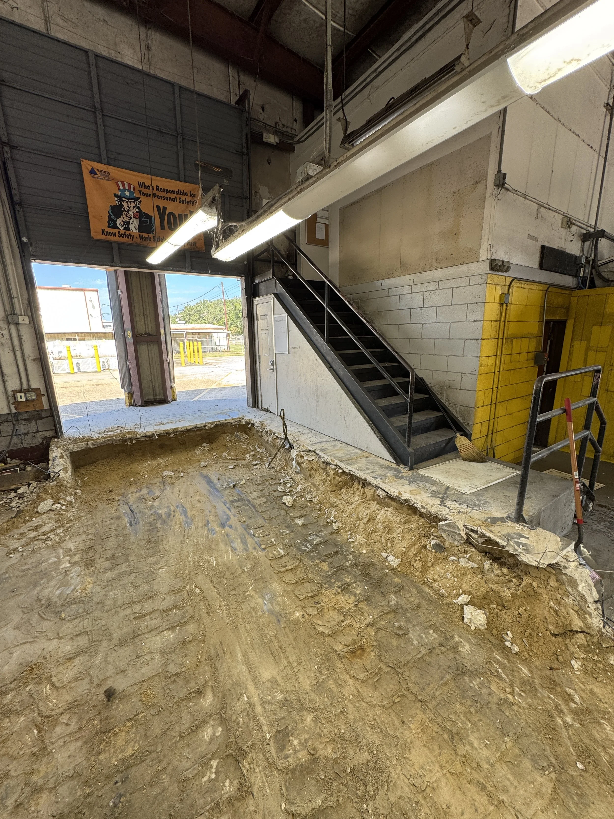  Interior concrete slab removed exposing dirt subgrade inside commercial warehouse. 