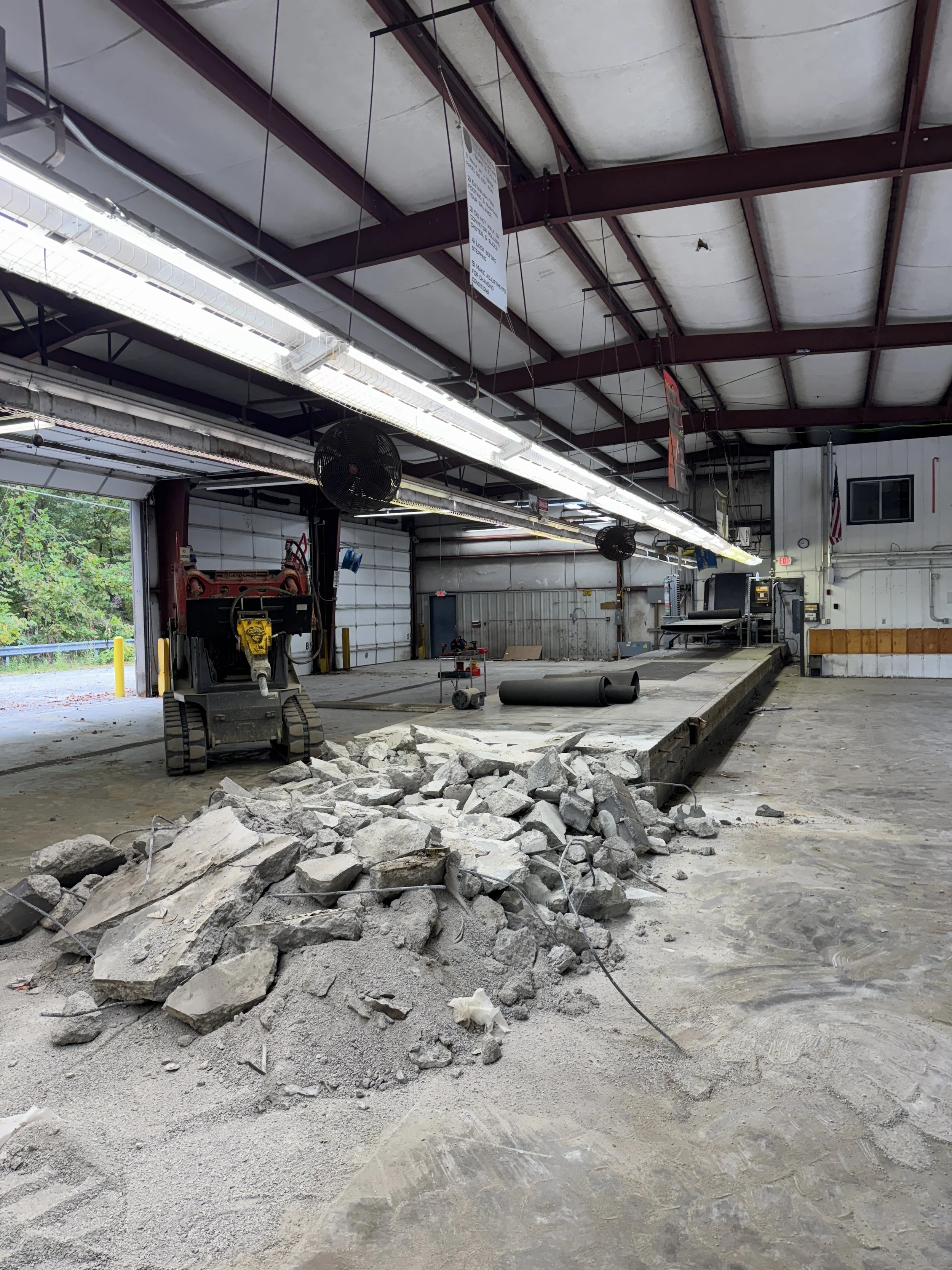  Skid steer removing broken interior slab during commercial concrete demolition. 