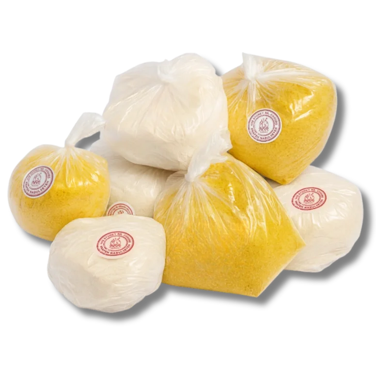 Several large bags of shredded cheese, including white and yellow varieties, sealed in plastic and placed against a black background.