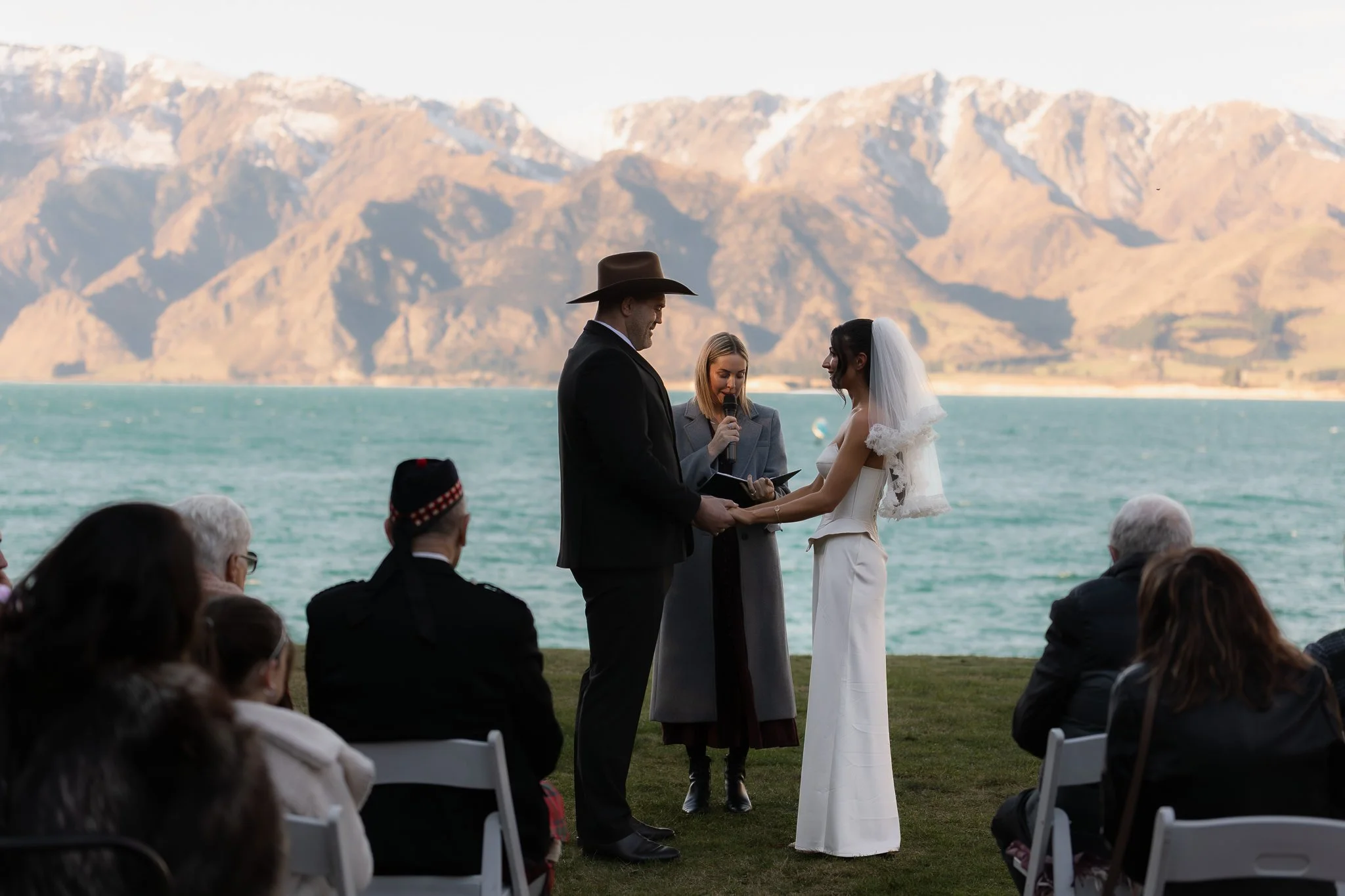 Couple standing at their wedding ceremony overlooking lake Hawea.