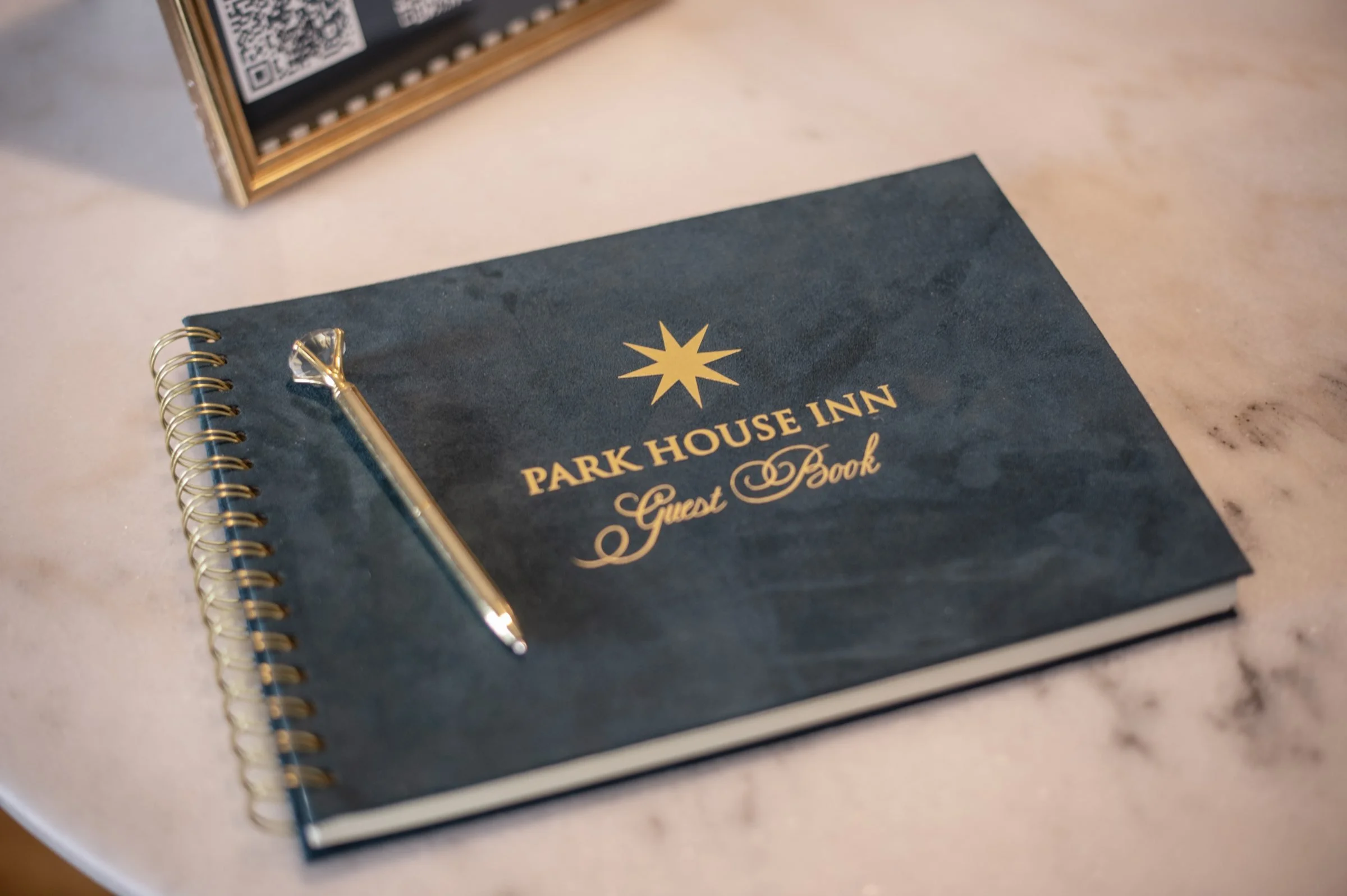 Park House Inn guest book and gold pen on a marble table