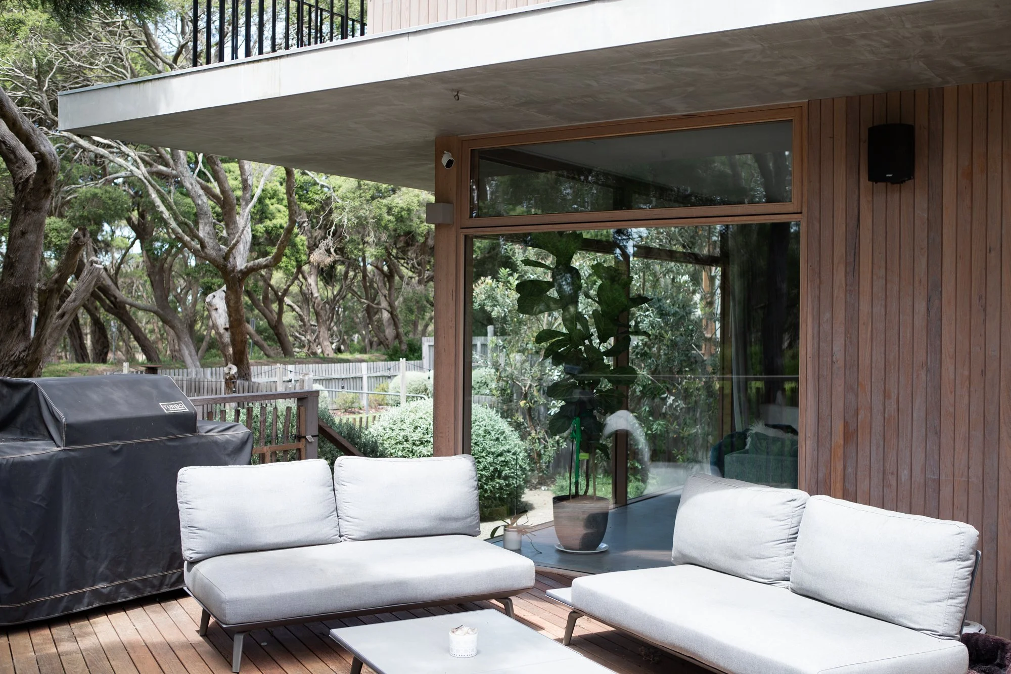 Residential window cleaning Torquay — timber clad home with large glass sliding doors and outdoor entertaining area
