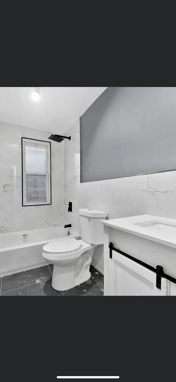 A modern house with a backyard swimming pool, surrounded by lounge chairs, purple plants, and trees, with hills in the background during daylight.