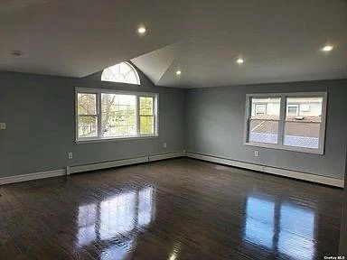 Close-up of shallow water with ripples and visible sand beneath, including small rocks and seaweed.