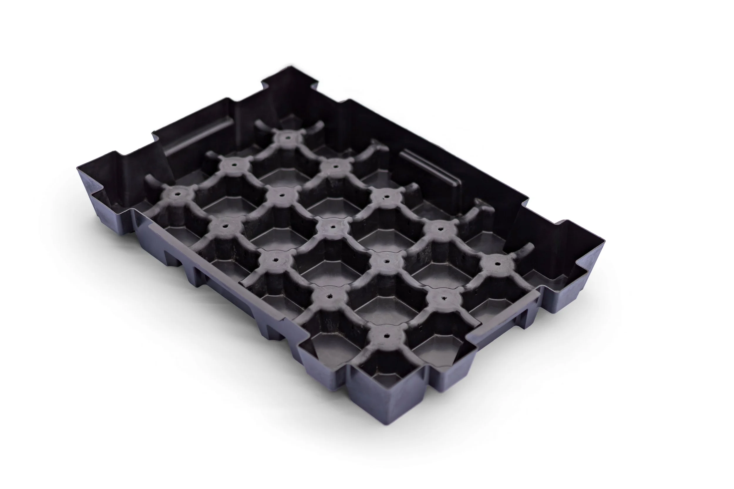 En svart plastlåda med ett mönster av små hål och koppar.