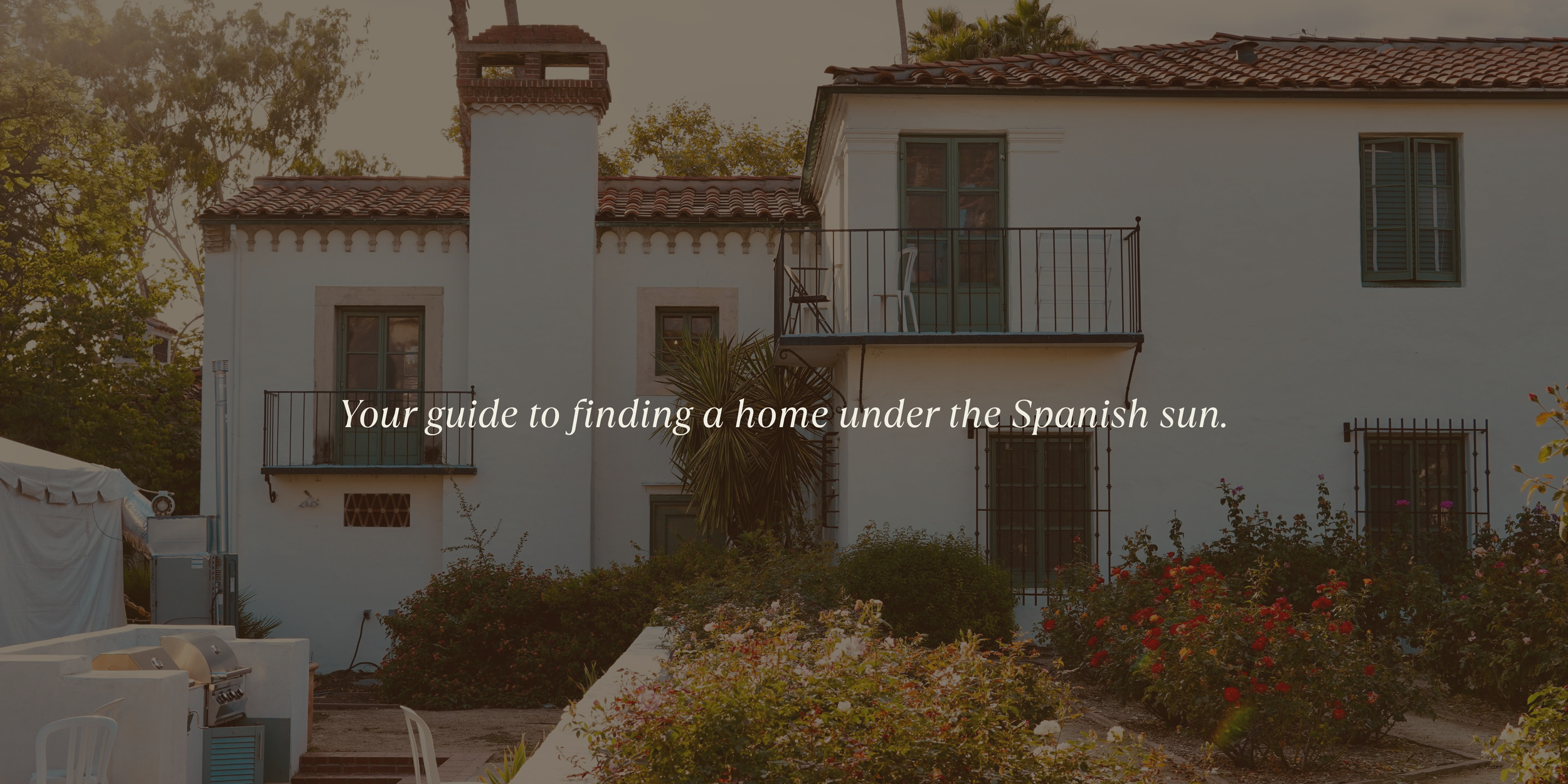 A photo of a white with blue Spanish country house with an over lay text of ' Your guide to finding a home under the Spanish sun.'