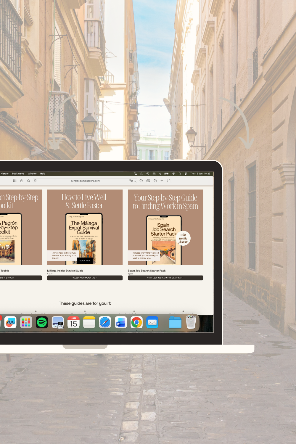 A laptop displaying guides for living and working in Spain on a narrow street with old buildings, balconies, and a cobblestone pavement.
