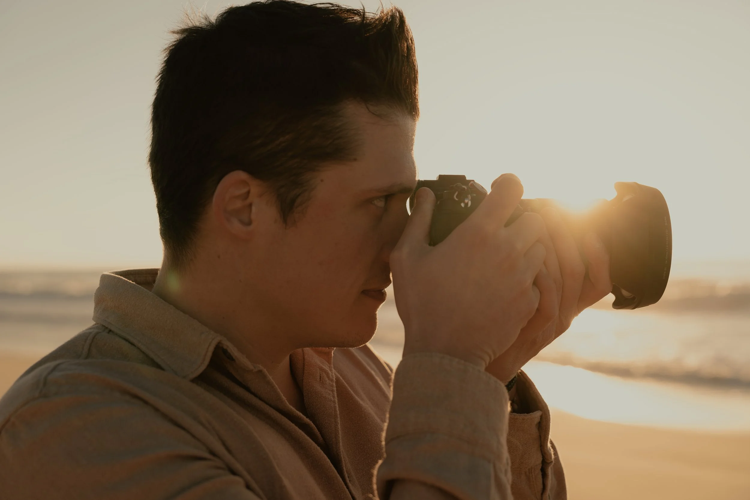Photographe de mariage en action lors d'une séance photo couple sur une plage des Landes au coucher du soleil