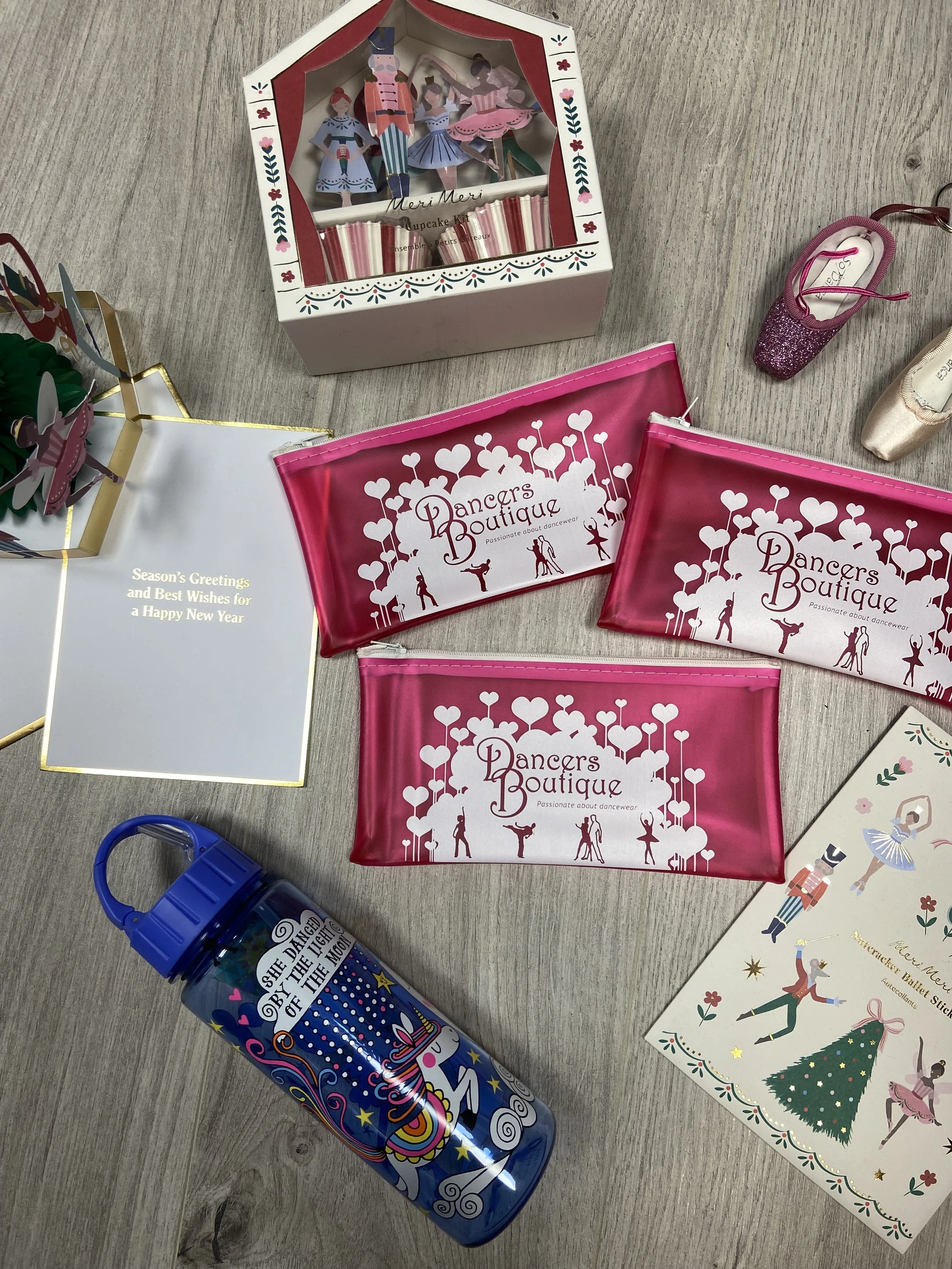 A range of gifts including a water bottle, Christmas card, cupcake kit, pointe shoe keyrings in pink, stickers and three Dancers Boutique pencil cases.
