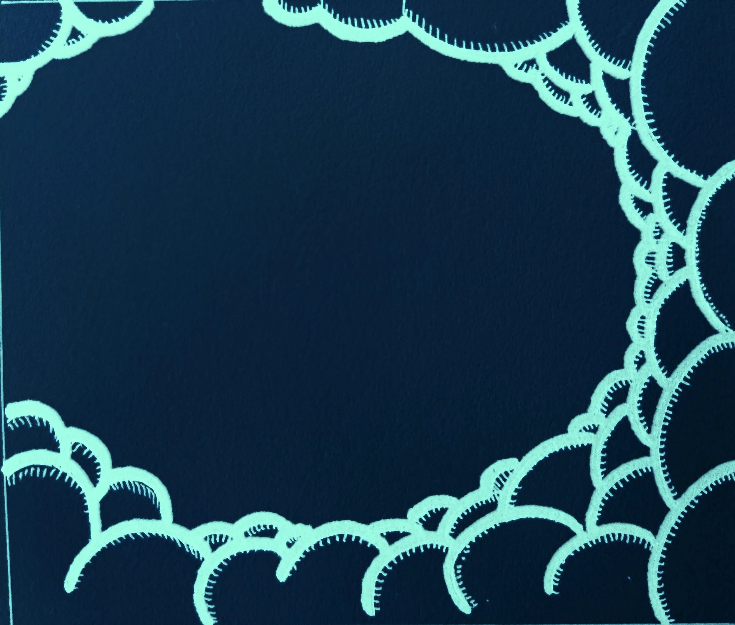 Close-up of a blue fabric with an intricate white lace pattern along the edge.