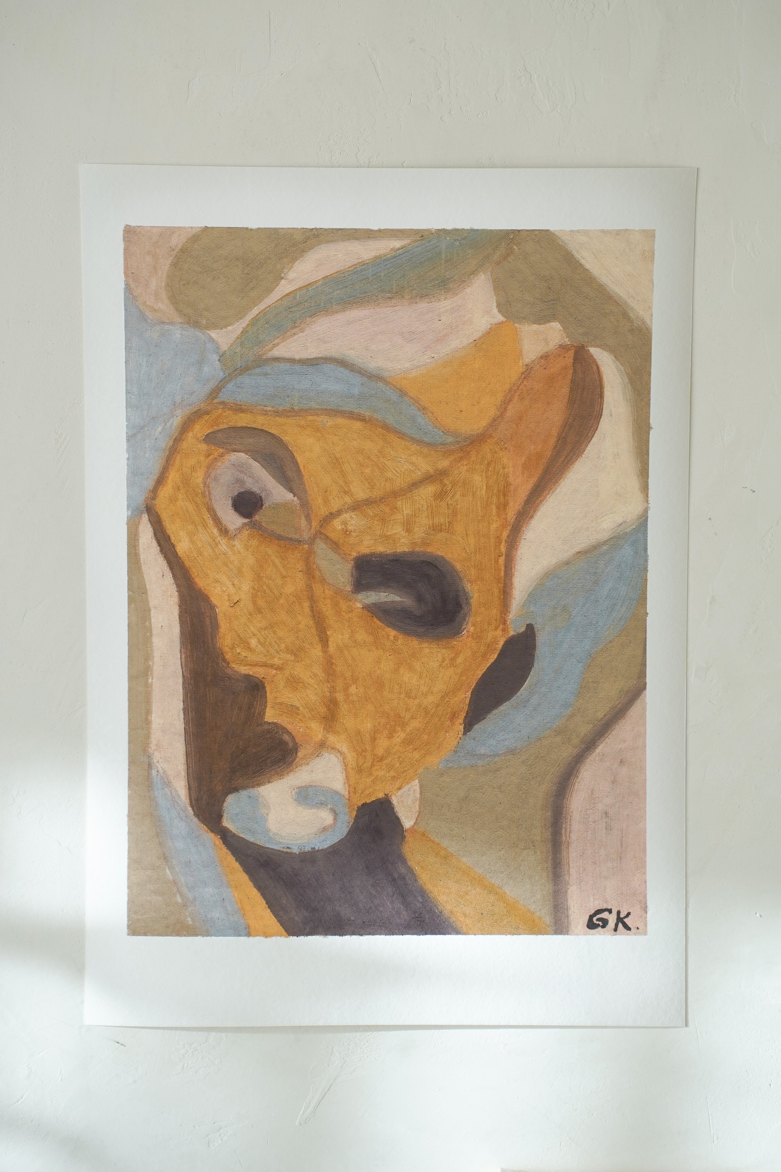 Painting of a goat's face in abstract style with warm earth tones and blue accents, signed GK.