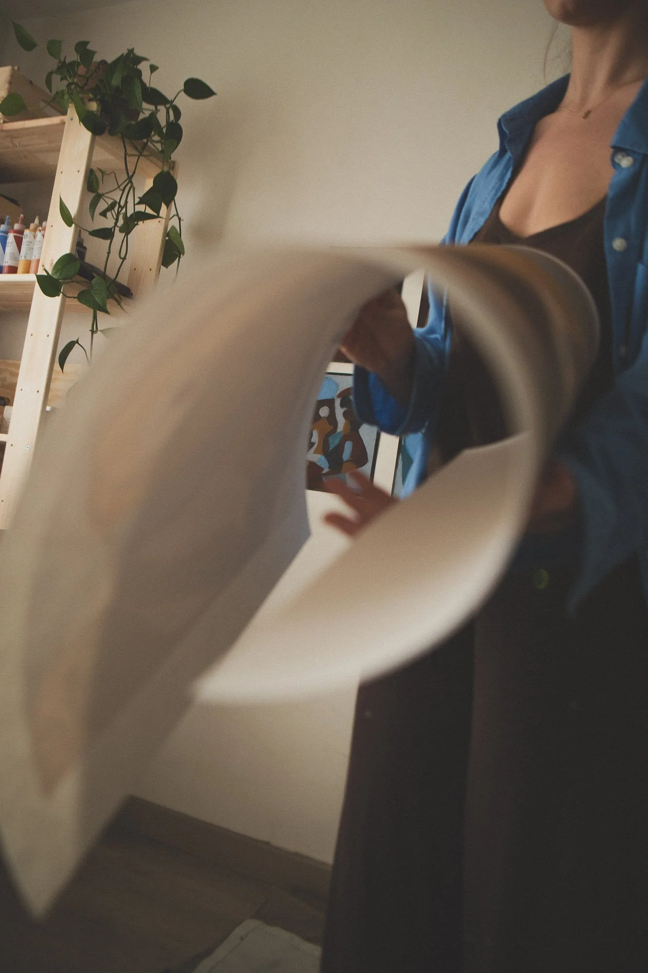 A Norwegian artist Giedre Koz, flipping through a large rolled-up abstract art poster in her art studio in Oslo. 