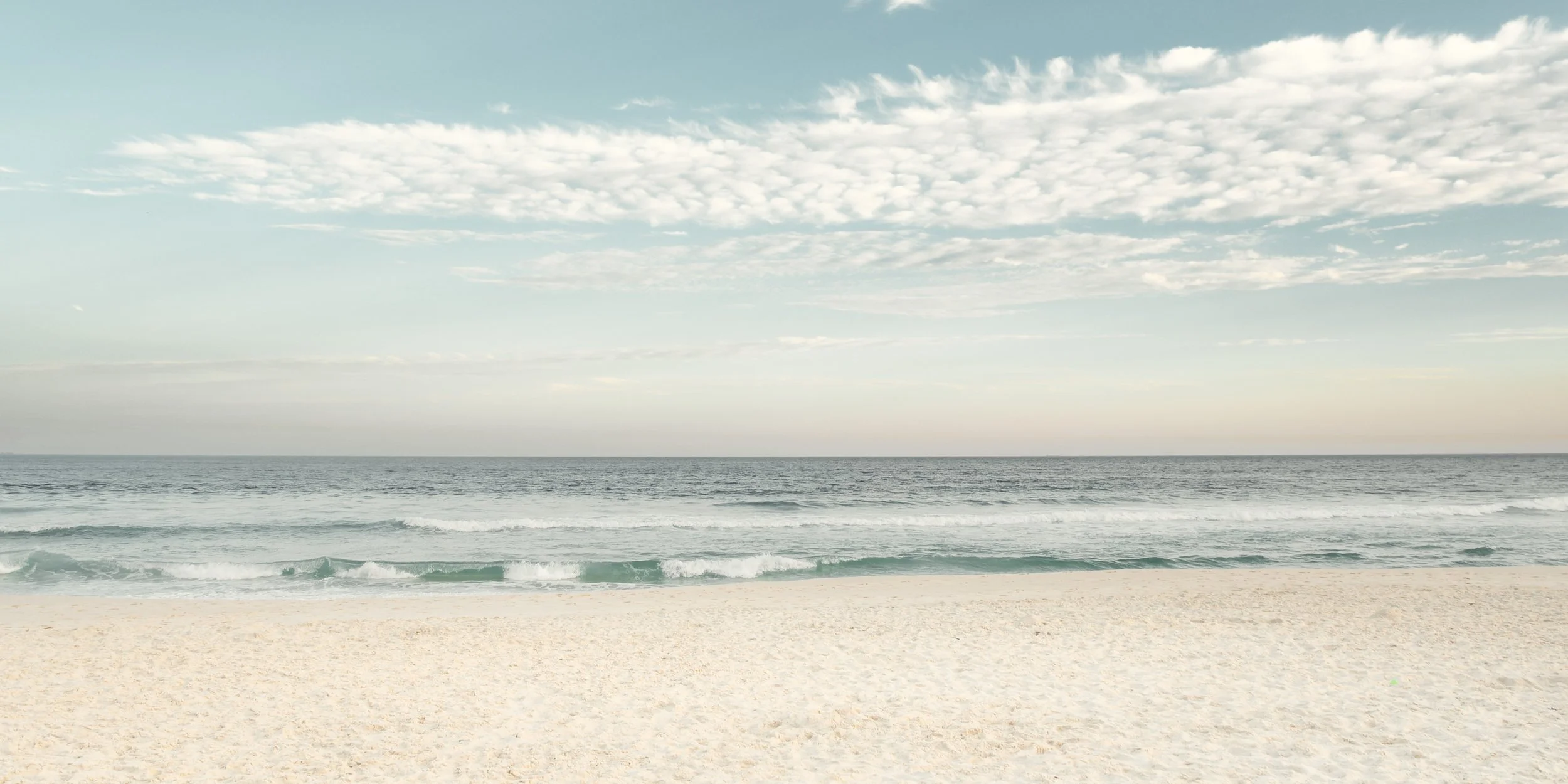 Fotografia fine art minimalista de praia no Rio de Janeiro com areia clara, mar calmo e céu suave, ideal para quem busca um quadro sereno para salas amplas, ambientes costeiros, espaços de descanso e projetos que pedem sensação de ordem visual e leve