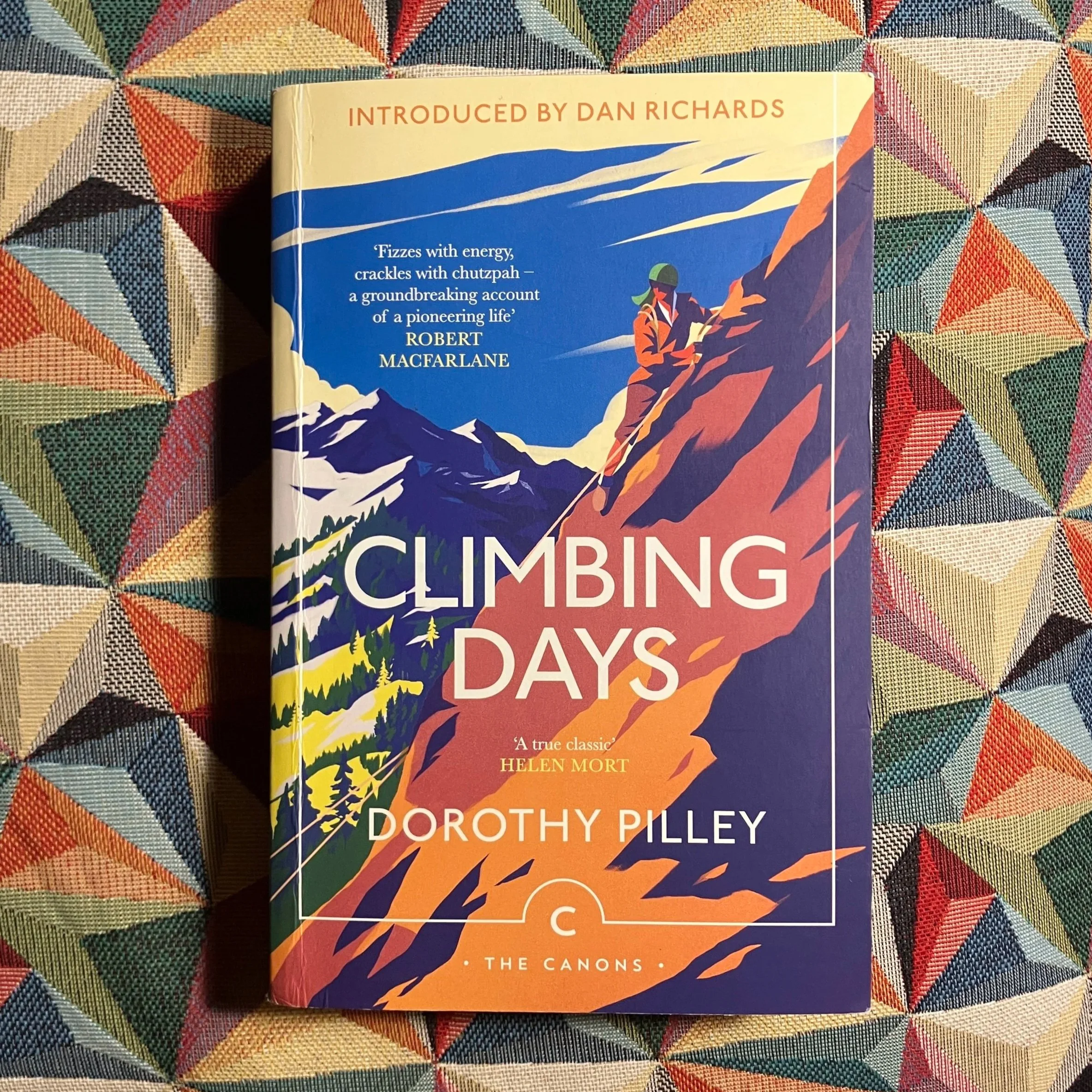 Book titled 'Climbing Days' by Dorothy Pilley – featuring an introduction by Dan Richards – with illustration of a femail climber on a mountain slope, mountains in the background, and bold colors.