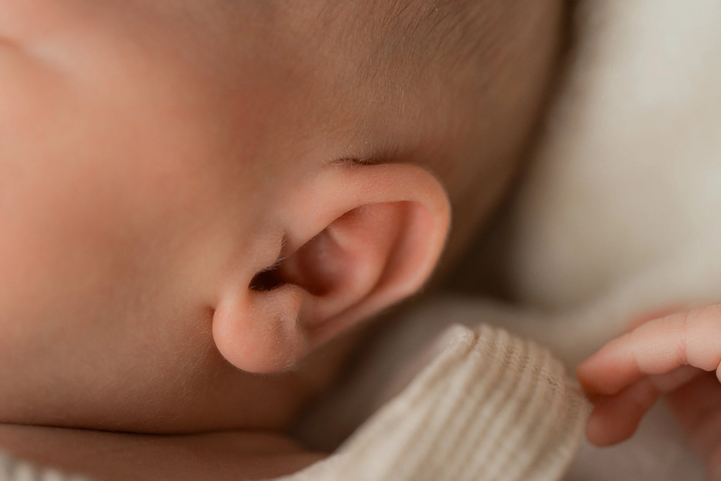Naheaufnahme eines Babys, das schläft und seine Hand hält