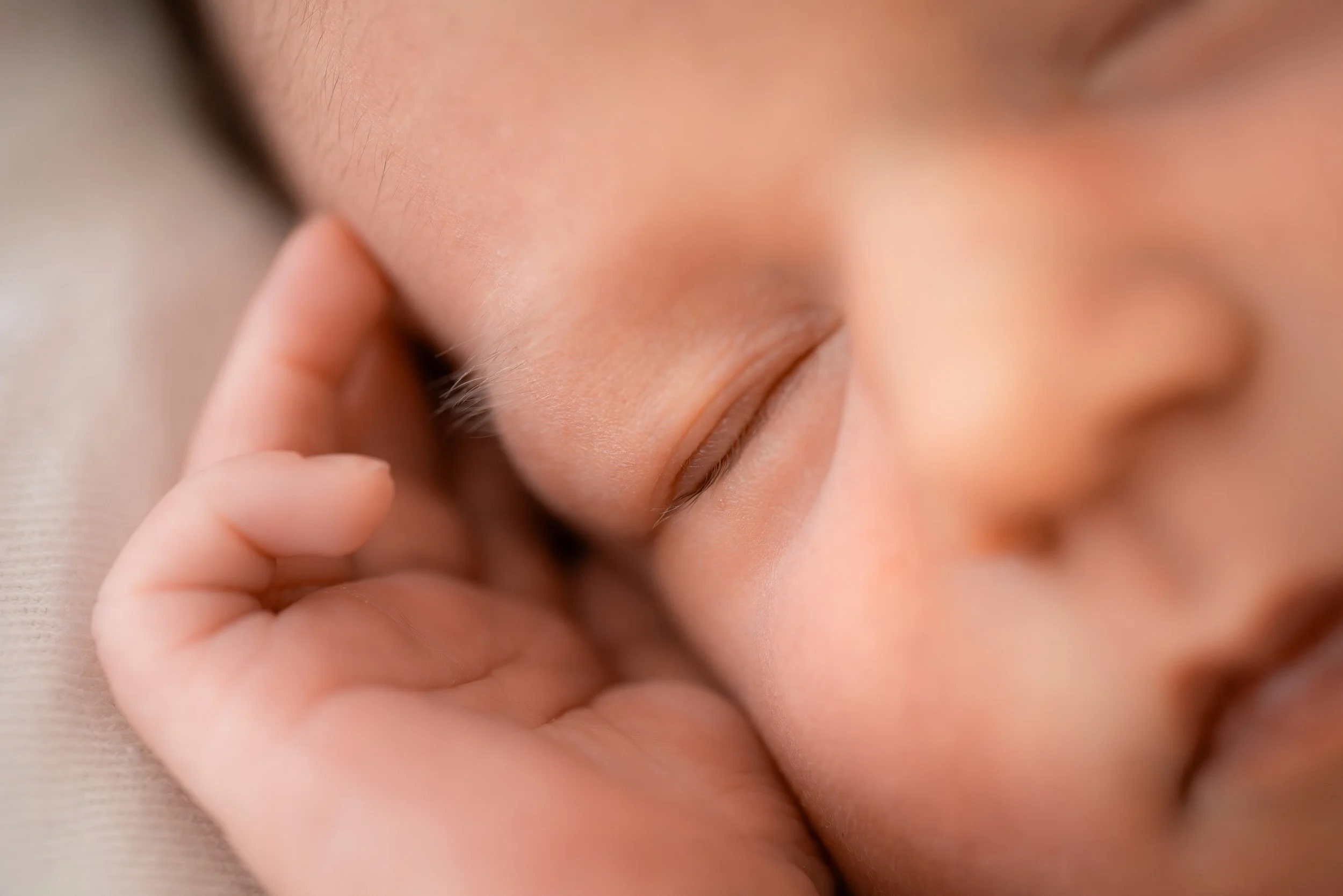 Nahaufnahme einer schlafenden Person mit geschlossenen Augen, die Hand berührt das Ohr.