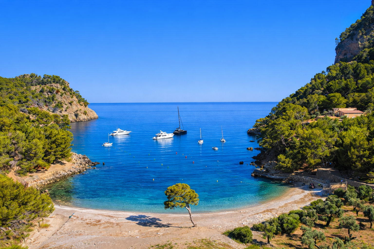 A scenic view of a small bay with calm blue waters, surrounded by green hills with trees, and boats anchored in the water.
